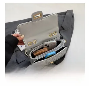 Top view of quilted silver bag interior showing multiple functional compartments and gold hardware