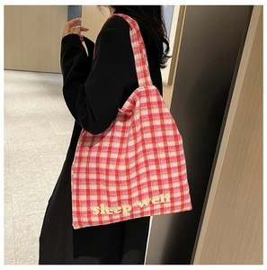 Pink plaid tote bag detail showing Sleep Well embroidery on soft knitted fabric