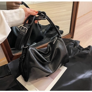 Detail of black faux leather texture and silver hardware on a Boston style bag