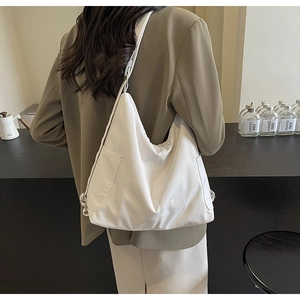 Detailaanzicht van een grote witte tote bag met een handig zijvak en stevige schouderriem
