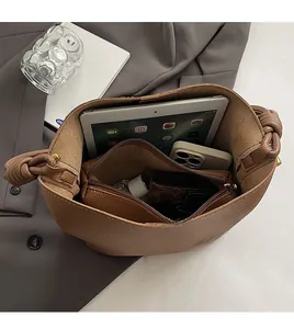 Detail view of large brown bucket bag with spacious interior and inner zipper pouch
