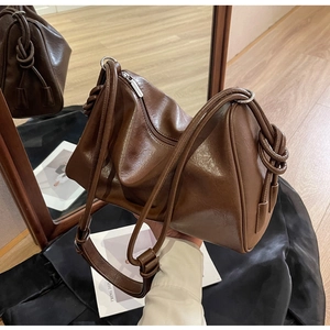 Detailed close-up of brown PU leather texture and braided rope knots on Boston bag