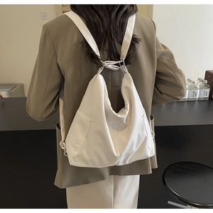 Moderne crèmewitte lederen rugzak gedragen door een model voor een stijlvolle casual look