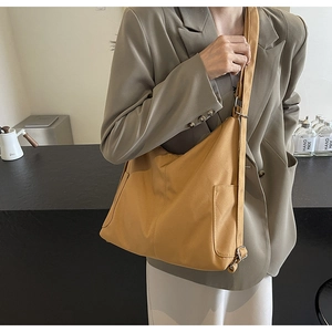 Detail van de gembergele grote crossbodytas met verstelbare schouderband van textiel