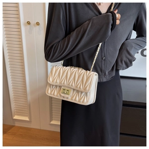Detail of cream quilted matelassé crossbody bag with gold chain and twist lock clasp