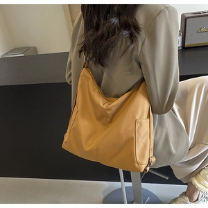 Detail van de gembergele nylon crossbody tas met verstelbare riem en handig zijvakje