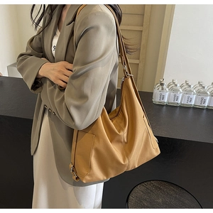Detail van de camel tote bag met de functionele zijrits en duurzame materiaalstructuur