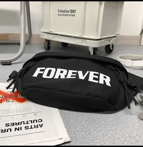Macro detail of black canvas waist bag with bold white FOREVER text and nylon strap
