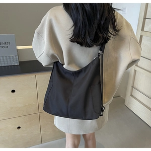 Achteraanzicht van een model met de grote zwarte nylon hobo schoudertas voor woon-werk