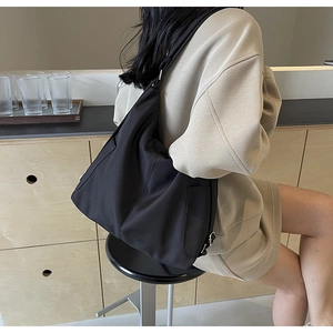Detail van zwarte nylon draagtas met brede schouderriem en ruim interieurontwerp