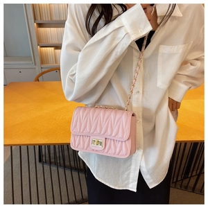 Detailed shot of pink quilted crossbody bag with gold twist lock and chain strap