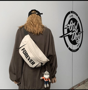 Street style view of white crossbody bag with Forever lettering and cute cow charm