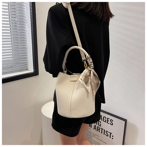 Detail of off-white lychee texture bucket bag with printed silk scarf on handle