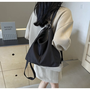 Detailoverzicht van grote zwarte canvas hobo tas met brede verstelbare schouderriem