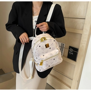 Nahaufnahme des weißen Mini-Rucksacks mit Bärenprint und goldenen Reißverschlüssen am Model