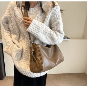 Brown leather Boston bag with side knot detail and adjustable strap for commuting