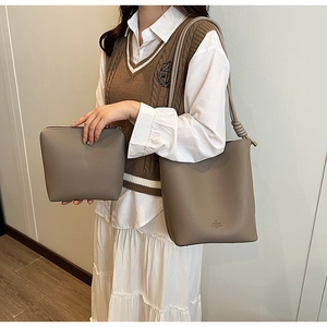 Close-up of grey pebble leather tote and matching pouch set with long shoulder strap