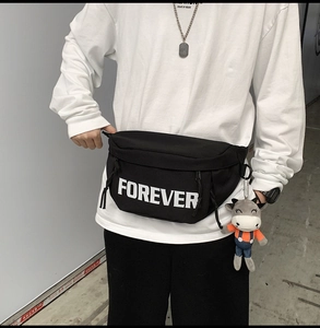 Detailed view of black nylon waist bag with Forever print and cute plush pendant