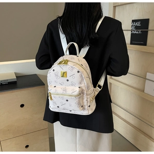 Detailansicht des weißen modischen Rucksacks mit Bärenmuster und goldenen Metallakzenten