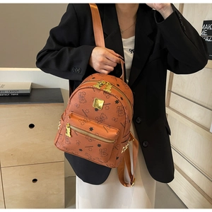 Nahaufnahme des braunen Mini-Rucksacks mit Bärenprint und goldenem Bären-Reißverschluss