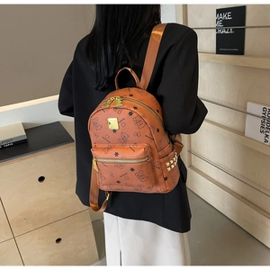 Detailansicht eines braunen Mini-Rucksacks mit Bärenprints und goldenen Nieten an der Seite