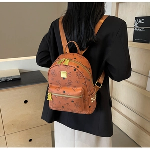 Nahaufnahme des braunen Lederrucksacks mit Bären-Stern-Print und Goldnieten