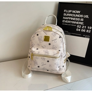Detailansicht eines cremefarbenen Mini-Rucksacks mit Teddybär-Print und Goldbeschlägen
