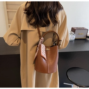 Braune Beuteltasche mit gemustertem Seidentuch in stilvollem Lifestyle-Ambiente
