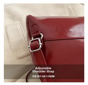 Detalle de la correa ajustable con hebilla de metal plateado en una mochila roja