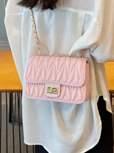 Light pink quilted crossbody bag with gold chain strap and turn-lock closure