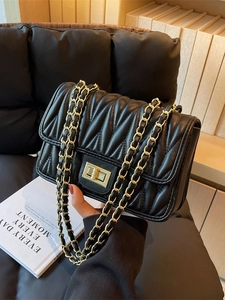 Elegant black quilted crossbody bag with gold chain strap and twist lock closure