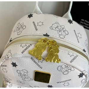 Detail eines weißen Rucksacks aus strukturiertem Leder mit Bärenprint und Goldreißverschluss