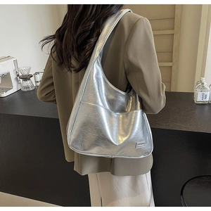 Side view of metallic silver hobo bag featuring stylish pleated texture and metal detail