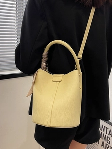 Pale yellow leather bucket bag with silk scarf handle and adjustable strap for women