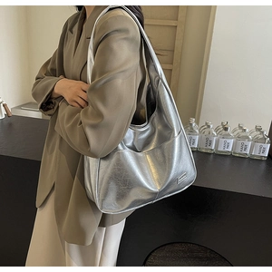 Close-up of silver cracked leather tote bag with metallic sheen and side pocket detail