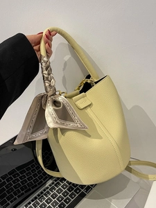 Pale yellow leather bucket bag with silk scarf handle and adjustable strap for women