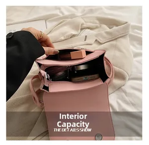 Détail de l'intérieur du sac en cuir rose montrant les compartiments et les poches