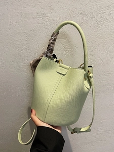 Pistachio green bucket bag with lychee texture and decorative silk scarf handle