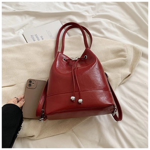 Borsa a secchiello in vernice rosso scuro con coulisse e dettaglio farfalla in metallo