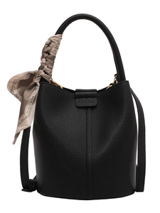 Chic black litchi leather bucket bag with a silk scarf tied on the top handle