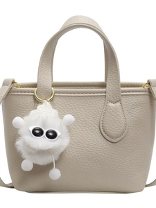 Minimalist beige pebble leather bucket bag with a cute monster fur charm accessory