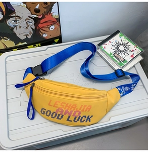 Detail of yellow nylon street bag with bright blue adjustable strap and pixelated text