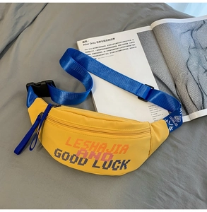 Close-up of bright yellow nylon waist bag with blue strap and pixel art text detail