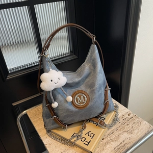 Detailed shot of wash canvas tote with leather straps and silver M logo charm