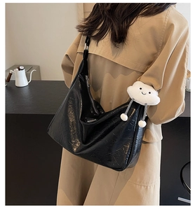 Détail du sac cabas noir avec accessoires argentés et breloque en peluche