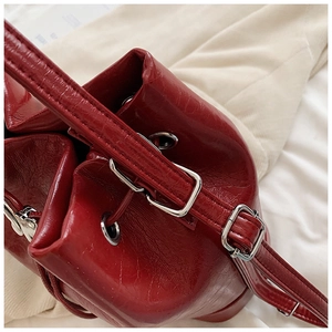 Macro di borsa a secchiello rossa lucida con occhielli argento e trama in pelle cerata