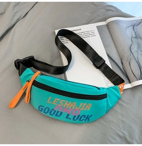 Close-up of mint green nylon waist bag featuring orange zipper cords and slogan