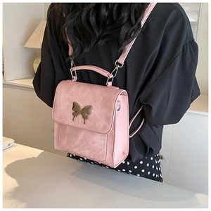 Vue arrière d'un mini sac à dos rose avec boucle papillon porté par un mannequin