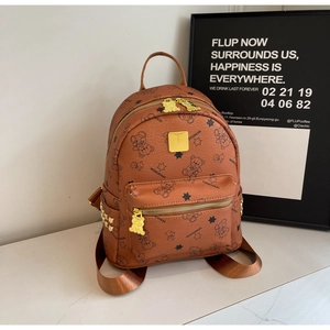 Detailansicht eines braunen Lederrucksacks mit Bärenprint und goldenen Reißverschlüssen