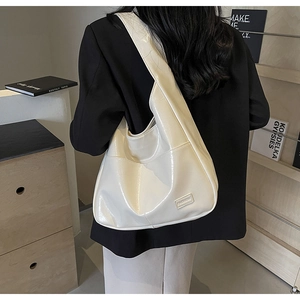 White glossy leather tote bag with FASHION label shown on a model in a modern office style